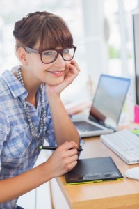 Portrait of smiling designer working on graphics tablet